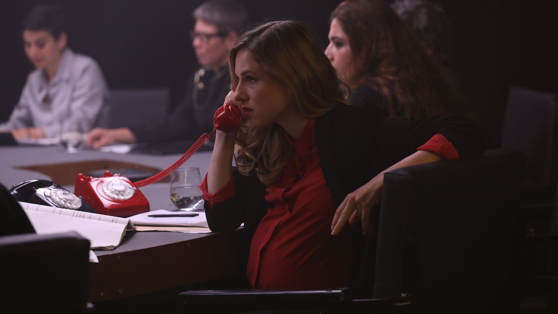 Za dve dvanact U velikého konferenčního kulatého stolu sedí 12 žen. Jedna těhotná žena, manažerka, telefonuje.