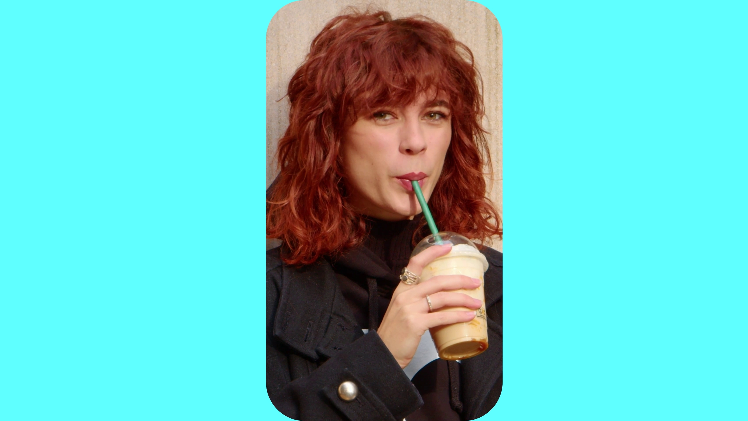 Žena pijící kafe brčkem z kelímku.