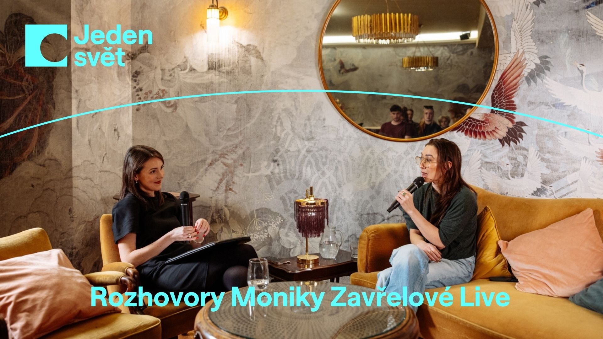 Grafika, na které je fotografie dvou žen sedících na pohovce a v křesle, vedoucích spolu hovor. Pod ní text: Rozhovory Moniky Zavřelové Live
