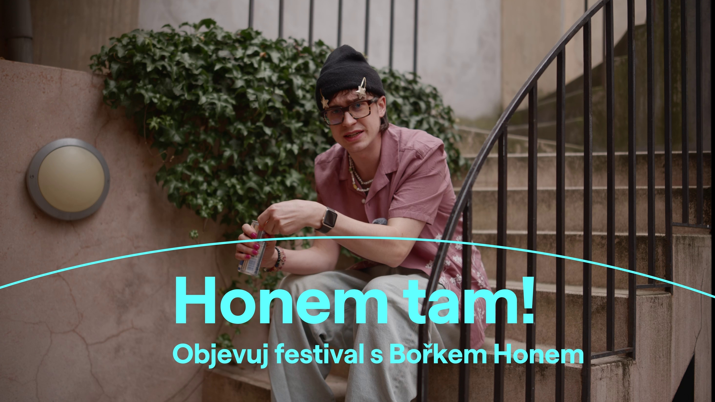 Muž sedí na schodech a drží plechovku.