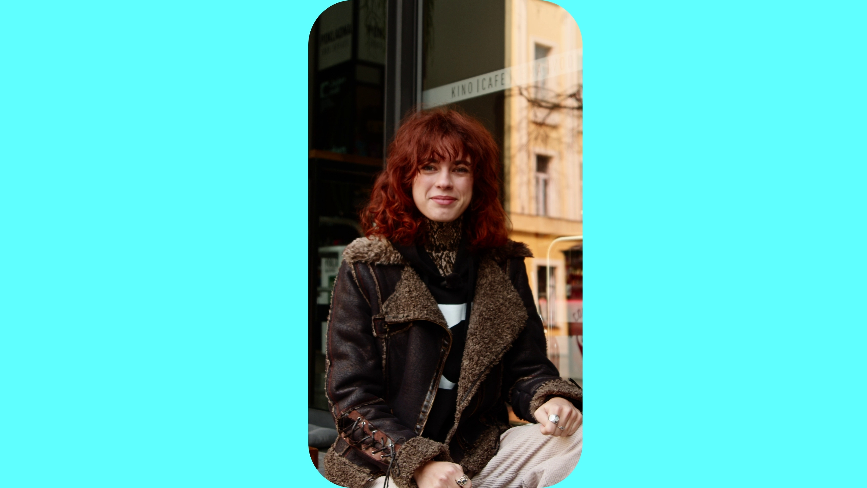 Žena sedí před kinem.