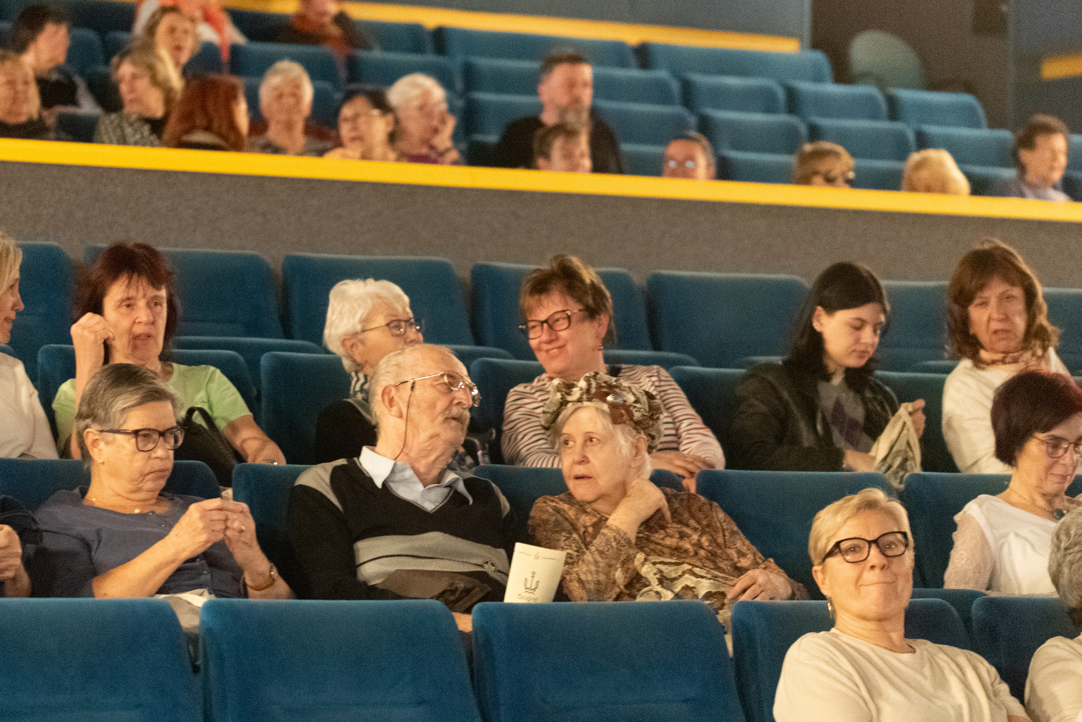 Publikum na festivalu Jeden svět, v jeho středu sedí pár v seniorním věku.