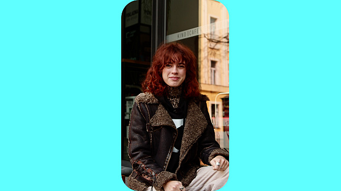 Žena sedí před kinem.